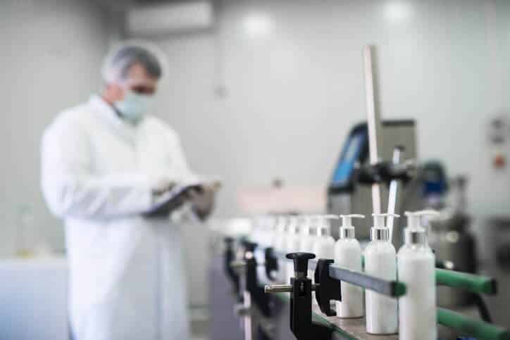 Regulatory affairs professional looking at the cosmetic products in a production line.