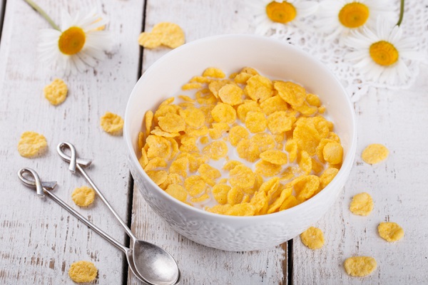 Flaked cereal is rolled out thin before being made into its shape, toasted, and sprayed