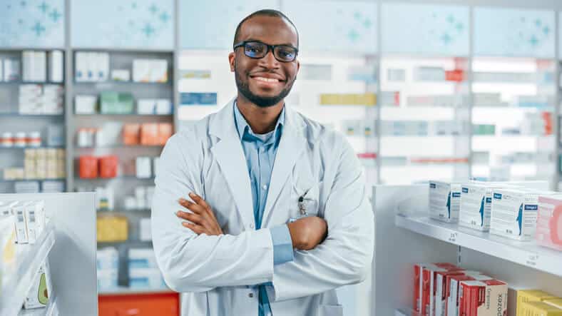 Male pharmaceutical professional smiling in a drugstore after pharmaceutical training.
