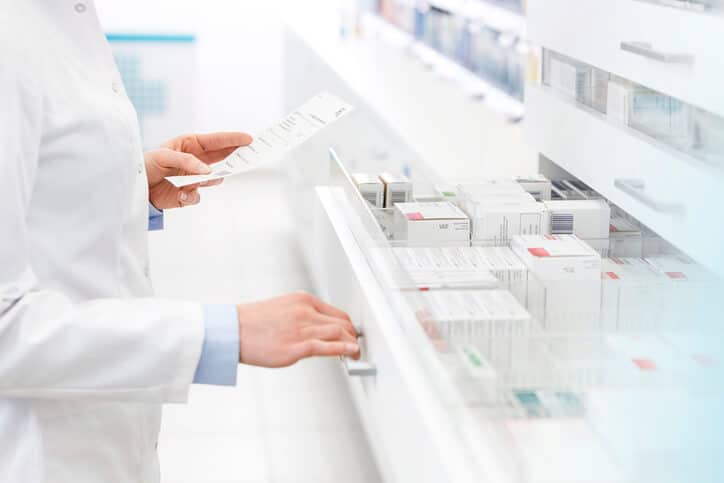 Quality assurance professional examining drugs in a pharmacy after pharmaceutical training.