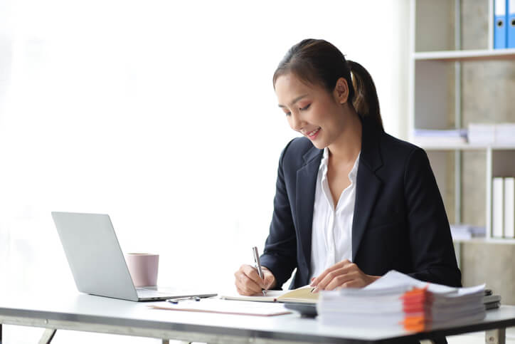Female reviewer working on a laptop in an office after regulatory affairs training