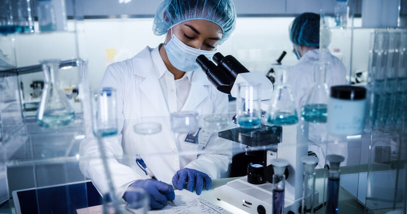 Two scientists writing down their findings during pharmaceutical research training