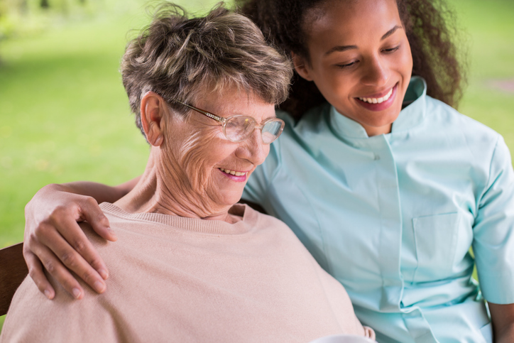 Friendly PSW interacting with an elderly female client after her personal support worker program.