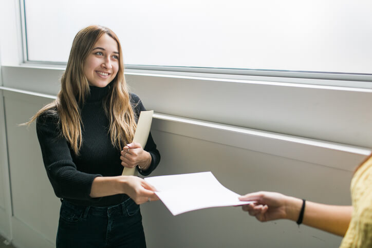 A personal support worker handing a document to a colleague