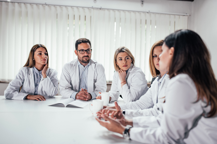 Healthcare professionals discussing the future impact of ongoing clinical trials.
