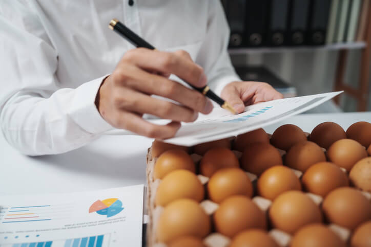 A production associate reviewing food safety documentation