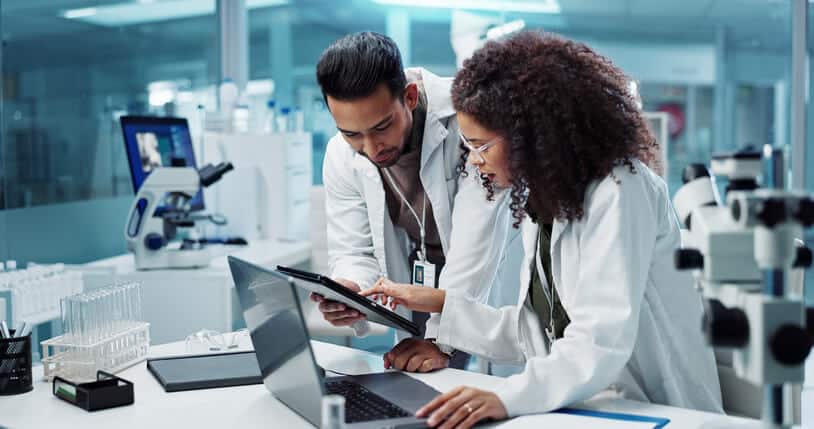 A team of male and female scientists conducting a pharmaceutical review in a lab after their pharmaceutical training