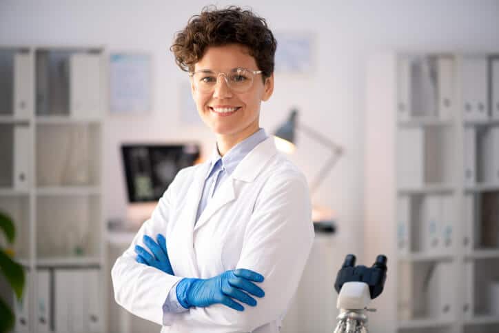 A smiling pharmaceutical professional in an office after completing her pharmaceutical training