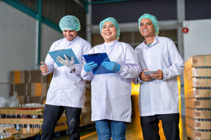 A team of workers conducting food quality checks in a facility after their food safety training