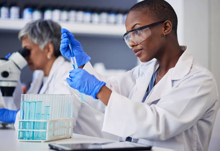 A pharmaceutical professional holding a pipette in a laboratory after pharmaceutical training