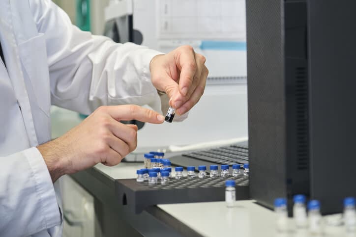 A scientist working with an HPLC machine in pharmaceutical school.