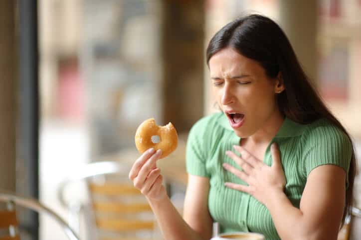 A woman reacts to discovering a physical hazard such as those covered in during Food Safety Training