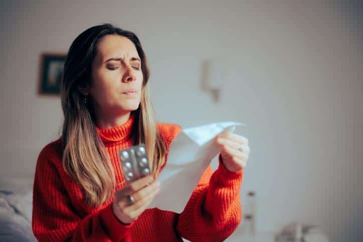 A patient reading the paper insert verified by a pharmaceutical school graduate through pharmacovigilance.