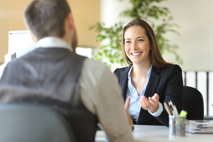 A male clinical research training graduate in an interview with a female employer
